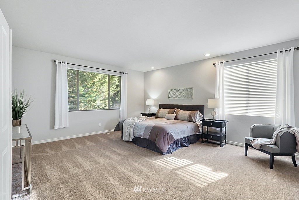 27714 Maple Ridge Way Southeast Maple Valley, WA 98038 - Photo 25 of 38 a spacious bedroom with a bed a couch and a window