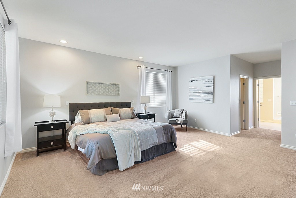 27714 Maple Ridge Way Southeast Maple Valley, WA 98038 - Photo 26 of 38 a spacious bedroom with a bed and a lamp