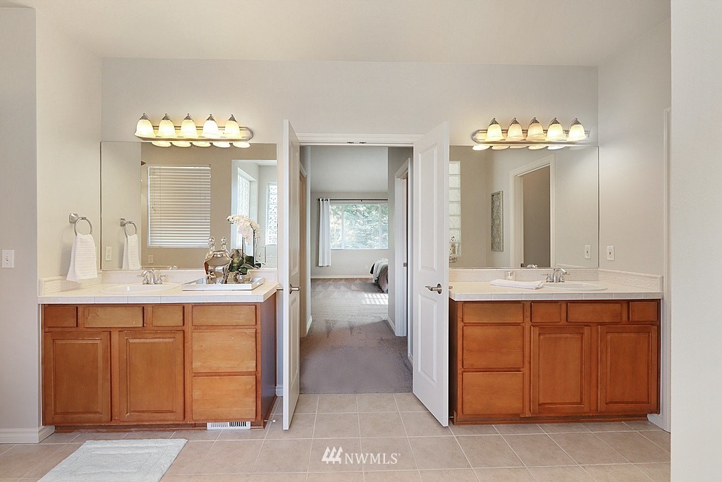 27714 Maple Ridge Way Southeast Maple Valley, WA 98038 - Photo 28 of 38 a bathroom with a double vanity sink and a mirror