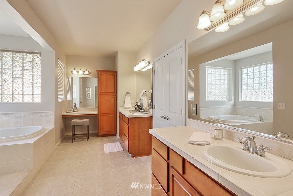27714 Maple Ridge Way Southeast Maple Valley, WA 98038 - Photo 29 of 38 a spacious bathroom with a sink a tub and a mirror