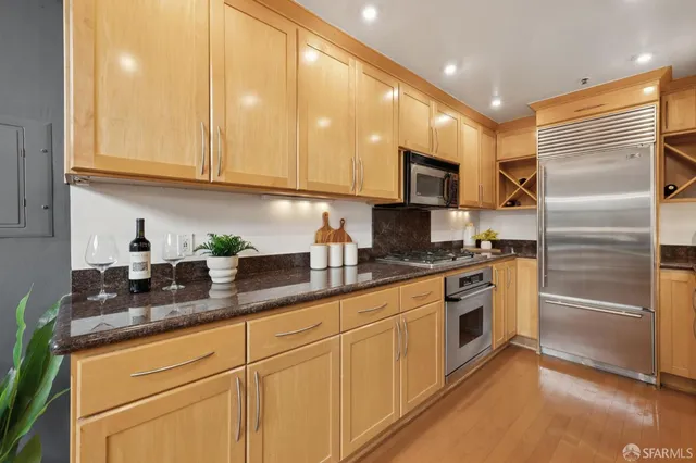 a kitchen with granite countertop stainless steel appliances a sink cabinets and a counter top space
