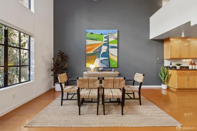 a view of a dining room with furniture a rug and wooden floor