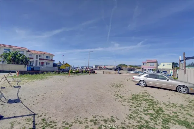 a view of a dry yard with wooden fence