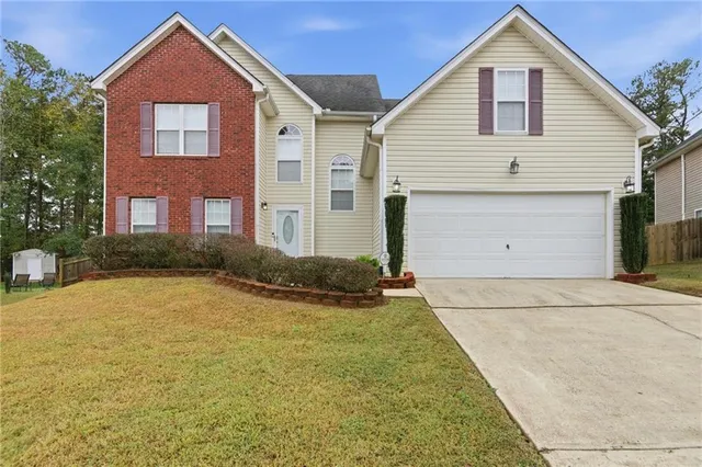 a front view of a house with a yard and garage