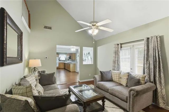 a living room with furniture a ceiling fan and a window