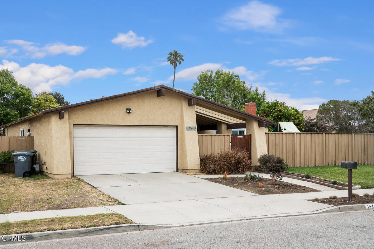1540 Port Drive Oxnard, CA 93035 - Photo 2 of 39 a front view of a house with a yard and garage
