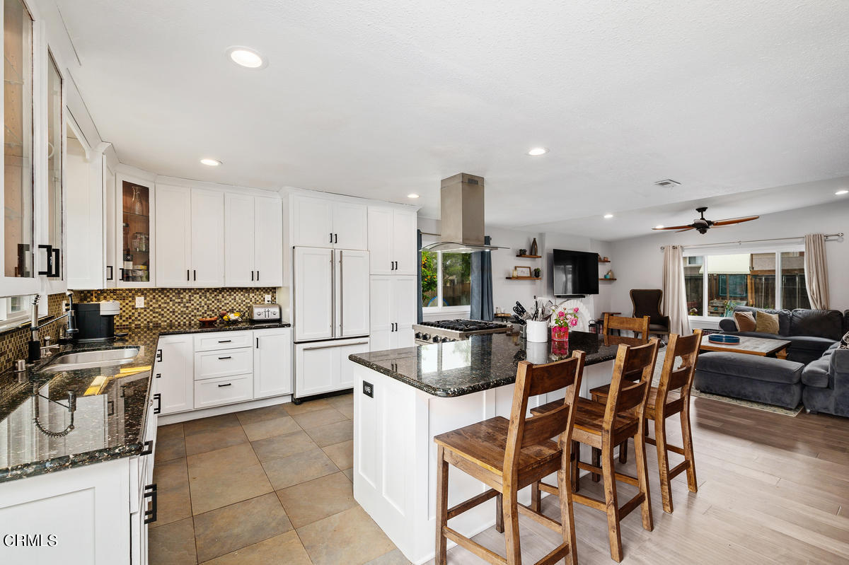 1540 Port Drive Oxnard, CA 93035 - Photo 13 of 39 a kitchen with stainless steel appliances granite countertop a stove a sink a oven a dining table and chairs with wooden floor