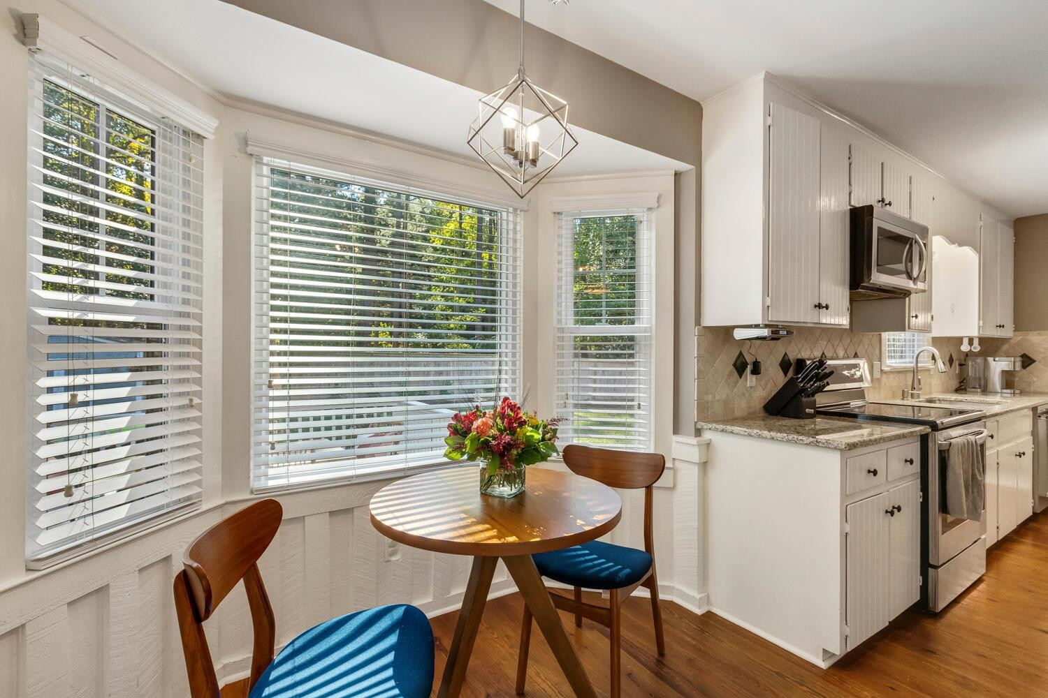6600 Vancouver Lane Raleigh, NC 27615 - Photo 18 of 53 a kitchen with stainless steel appliances granite countertop a stove a sink dishwasher and a dining table with wooden floor