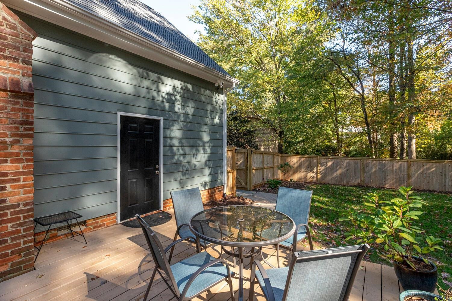 6600 Vancouver Lane Raleigh, NC 27615 - Photo 40 of 53 a view of a patio with table and chairs potted plants and wooden fence