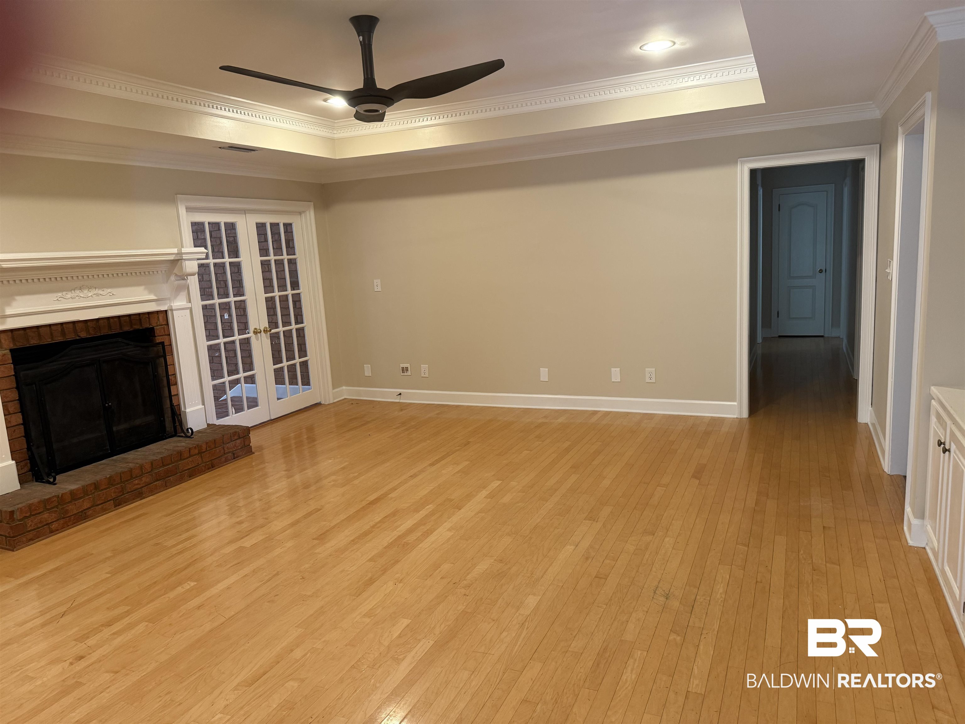 508 Barbara Court Daphne, AL 36526 - Photo 4 of 16 Unfurnished living room featuring crown molding, a ceiling fan, a raised ceiling, and light wood finished floors