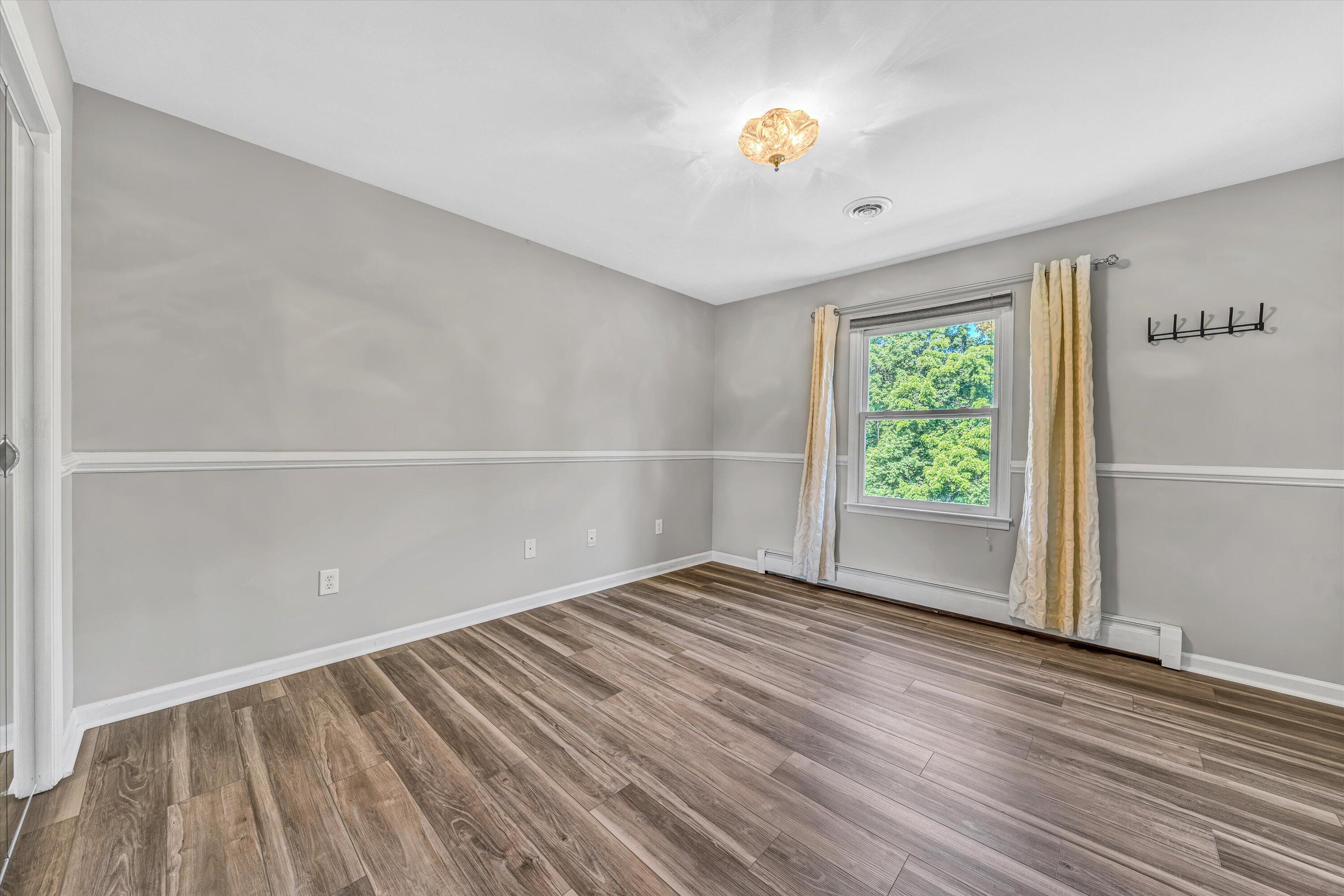 395 Middle Valley Road Hardy, VA 24101 - Photo 26 of 66 a view of an empty room with a window and wooden floor