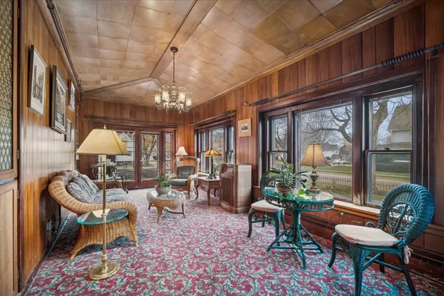 a dining room with furniture a chandelier and wooden floor