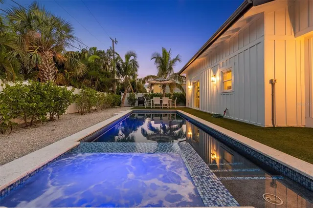 a view of a backyard with a table and chairs under palm trees