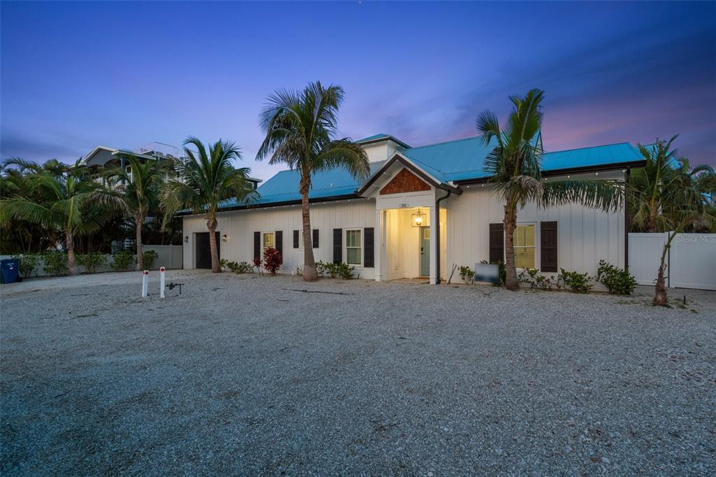 305 73rd Street Holmes Beach, FL 34217 - Photo 2 of 59 a view of a house with a yard and palm trees