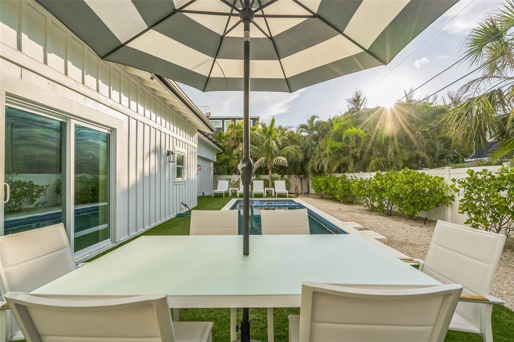 305 73rd Street Holmes Beach, FL 34217 - Photo 21 of 59 a view of a patio with a table and chairs under an umbrella