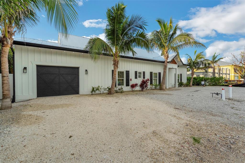 305 73rd Street Holmes Beach, FL 34217 - Photo 25 of 59 a front view of a house with a yard and garage