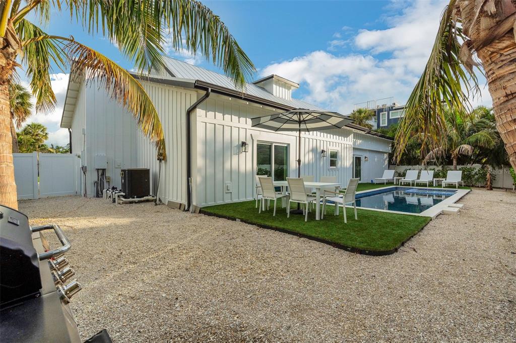 305 73rd Street Holmes Beach, FL 34217 - Photo 31 of 59 a view of a white house with a yard and potted plants