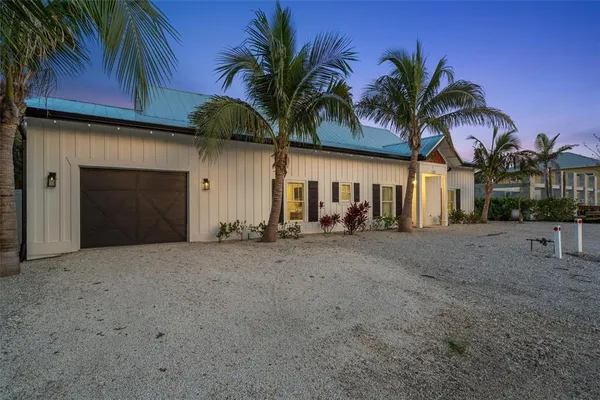 a view of a house with a yard and potted plants