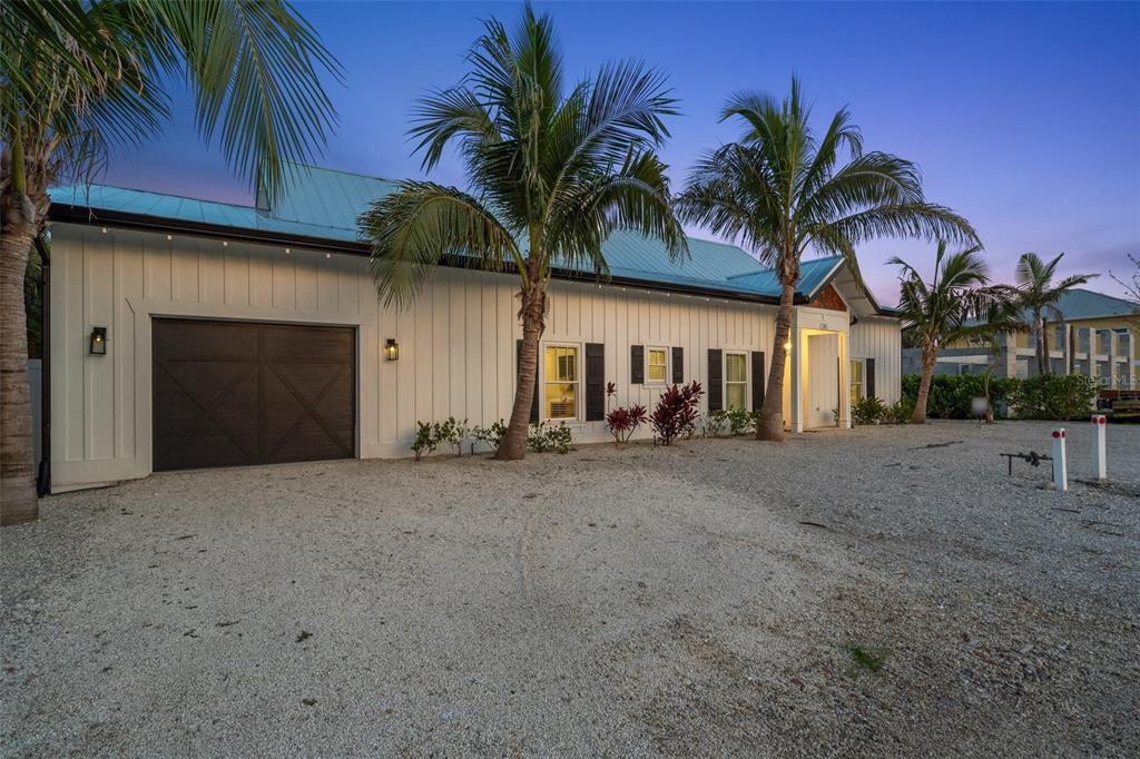 305 73rd Street Holmes Beach, FL 34217 - Photo 4 of 59 a view of a house with a yard and potted plants