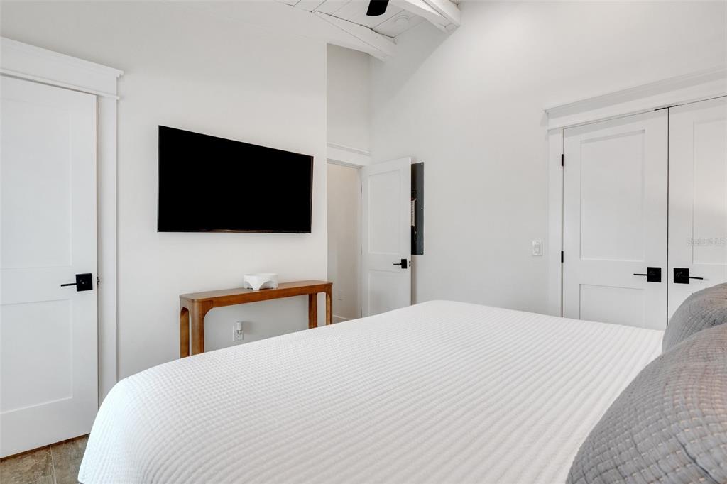 305 73rd Street Holmes Beach, FL 34217 - Photo 45 of 59 a bedroom with a bed and a flat screen tv