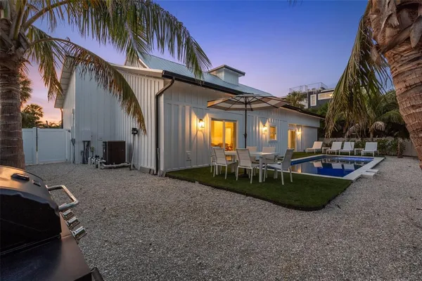 a view of a house with backyard and sitting area