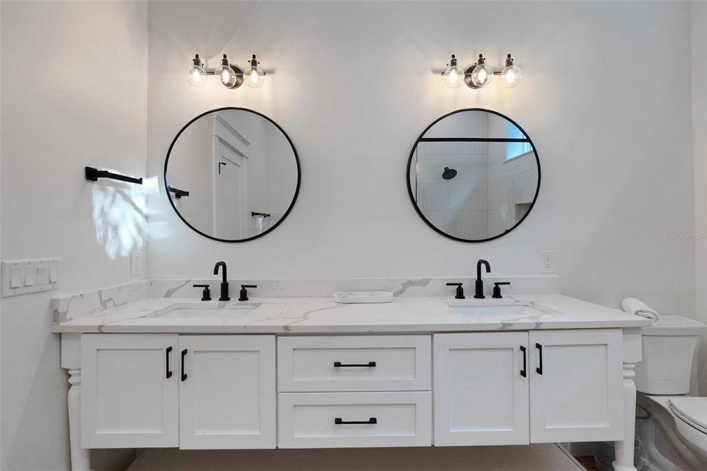 305 73rd Street Holmes Beach, FL 34217 - Photo 55 of 59 a bathroom with double vanity sinks and a mirror