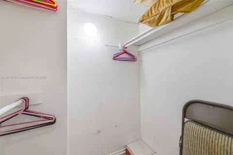 a bedroom with two beds and a dresser next to a window