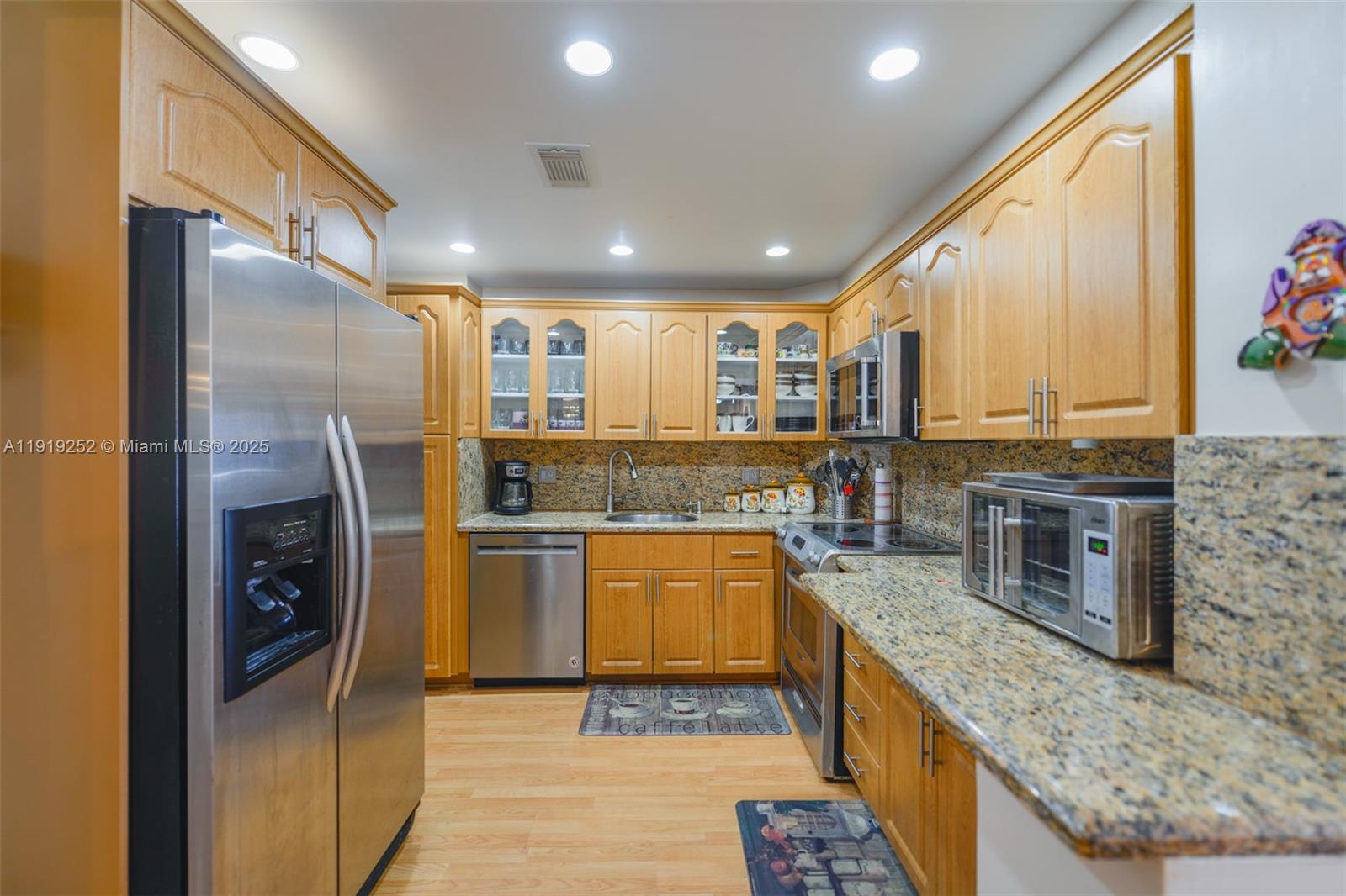 1985 South Ocean Drive, Unit 6J Hallandale Beach, FL 33009 - Photo 9 of 38 a kitchen with stainless steel appliances granite countertop a stove top oven a sink and a refrigerator
