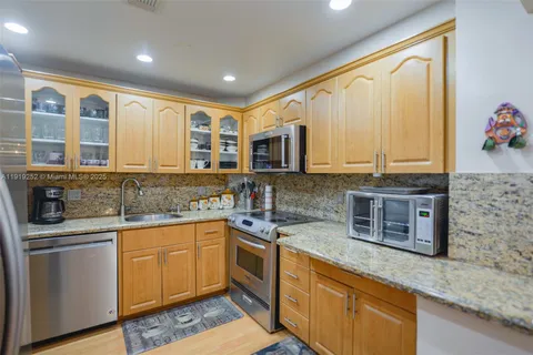 a kitchen with stainless steel appliances granite countertop a refrigerator and a sink
