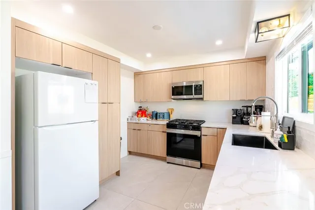 a kitchen with stainless steel appliances a refrigerator sink stove microwave and cabinets