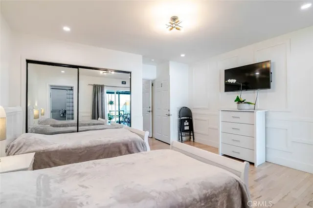 a bedroom with a large bed and a flat screen tv