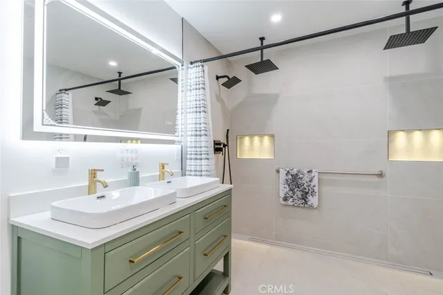 a bathroom with a sink mirror and a shower