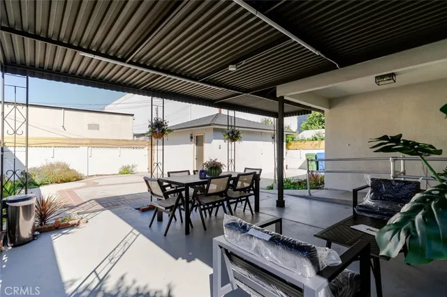 a view of a patio with table and chairs potted plants with floor to ceiling window