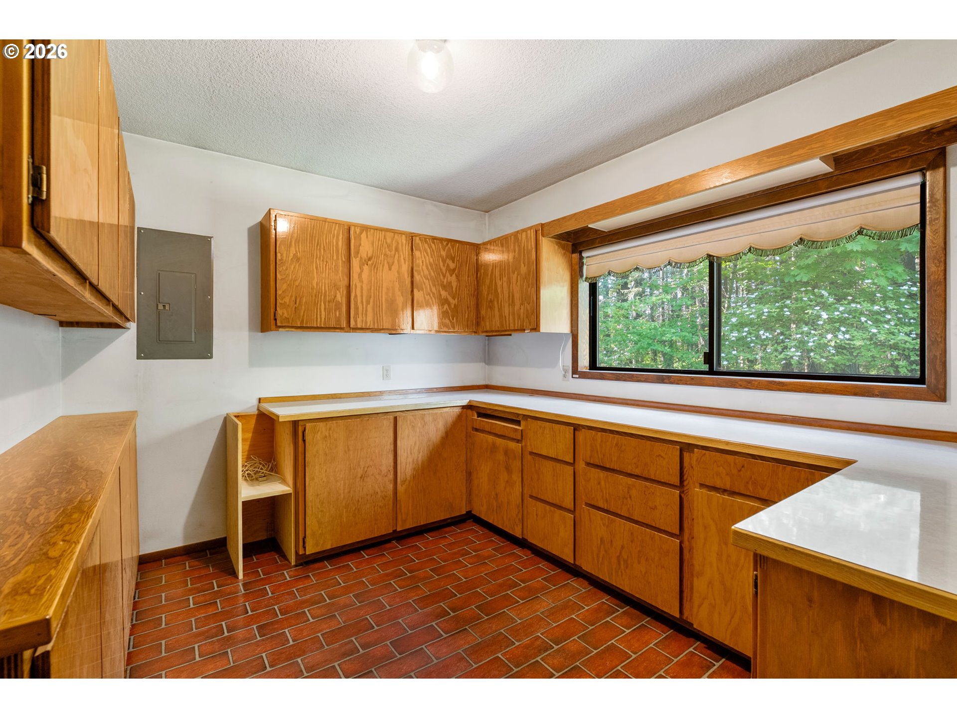 586 Northwest Loop Road White Salmon, WA 98672 - Photo 30 of 48 a kitchen with wooden cabinets a sink and a window