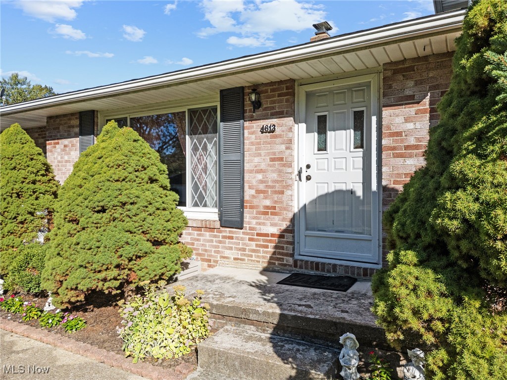 Property entrance featuring brick siding and covered porch
