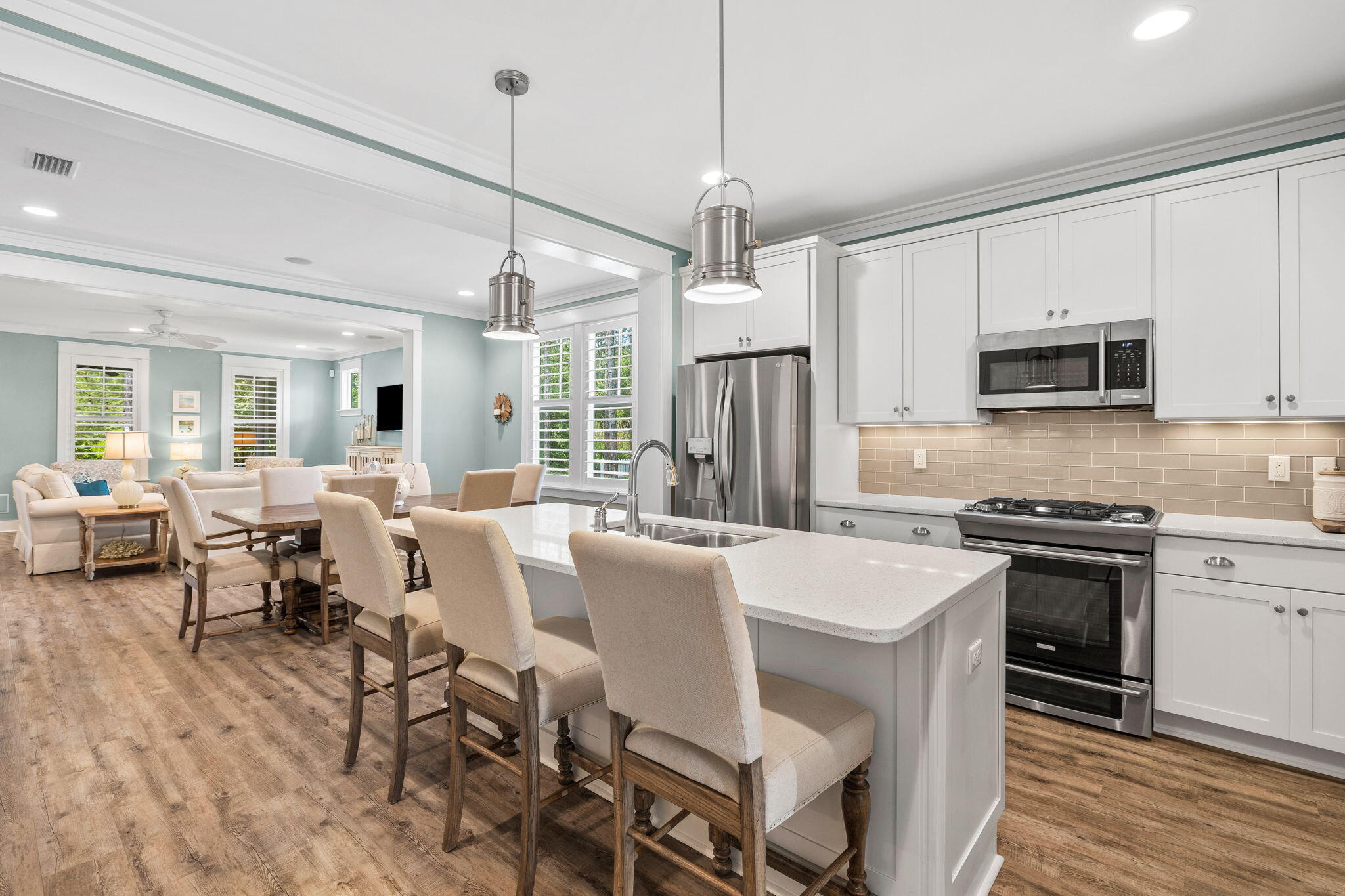 227 Jack Knife Drive Inlet Beach, FL 32461 - Photo 18 of 54 a large kitchen with kitchen island granite countertop a stove a sink a dining table and chairs with wooden floor