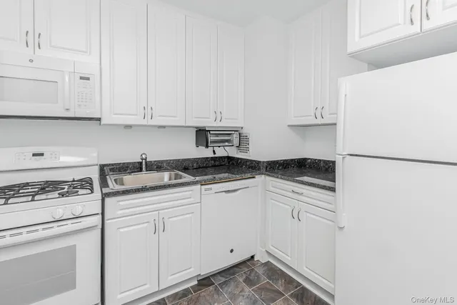 a kitchen with white cabinets and white appliances