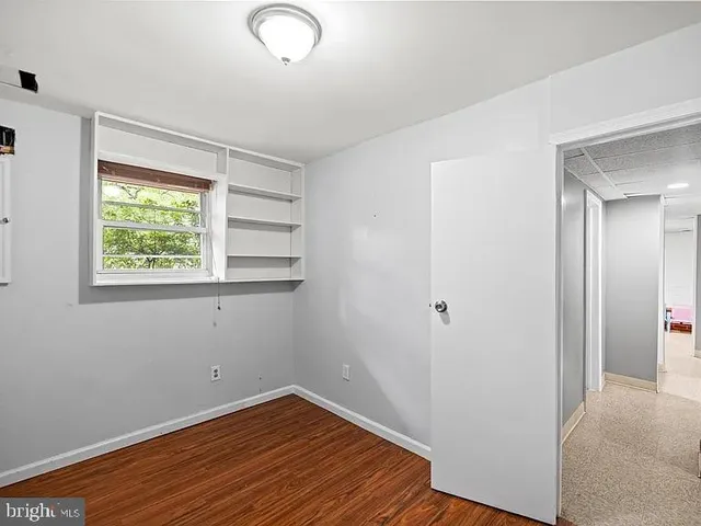 a view of a room with wooden floor and window