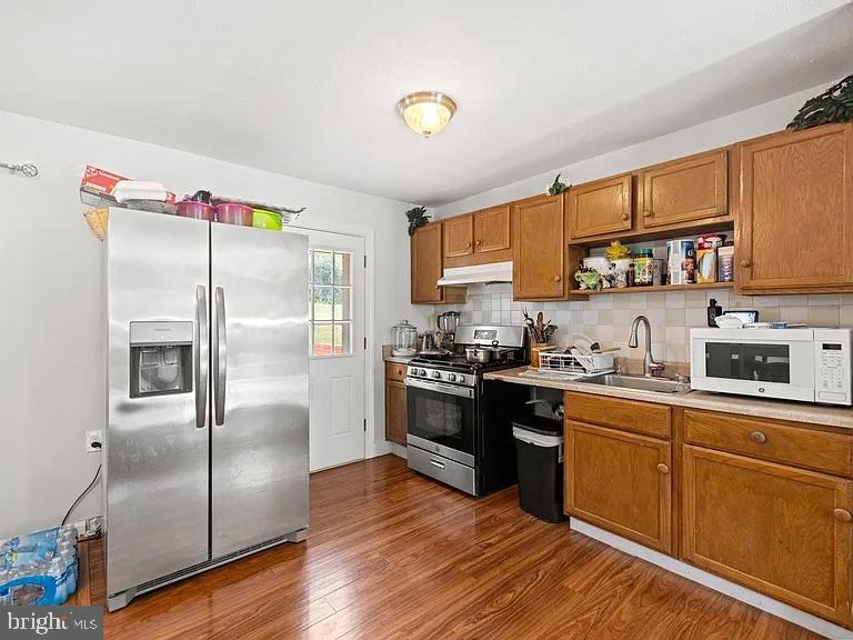 5007 Odessa Road College Park, MD 20740 - Photo 4 of 20 a kitchen with stainless steel appliances granite countertop a refrigerator a sink dishwasher a stove with wooden cabinets and floor