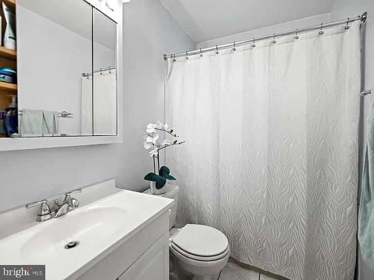 5007 Odessa Road College Park, MD 20740 - Photo 8 of 20 a bathroom with a sink a toilet and shower curtain