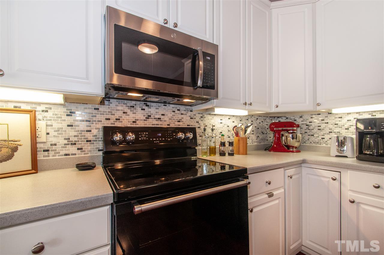 3615 Lion Ridge Court Raleigh, NC 27612 - Photo 12 of 30 a kitchen with stainless steel appliances a stove microwave and cabinets