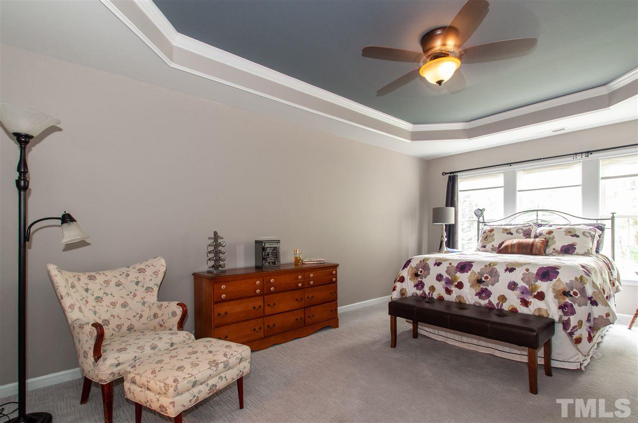 3615 Lion Ridge Court Raleigh, NC 27612 - Photo 18 of 30 a bedroom with bed and a chandelier