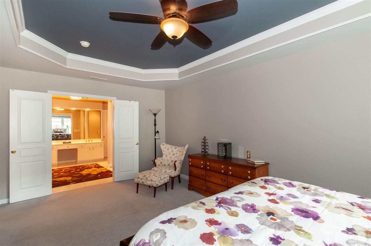 3615 Lion Ridge Court Raleigh, NC 27612 - Photo 19 of 30 a bedroom with a bed and a chandelier