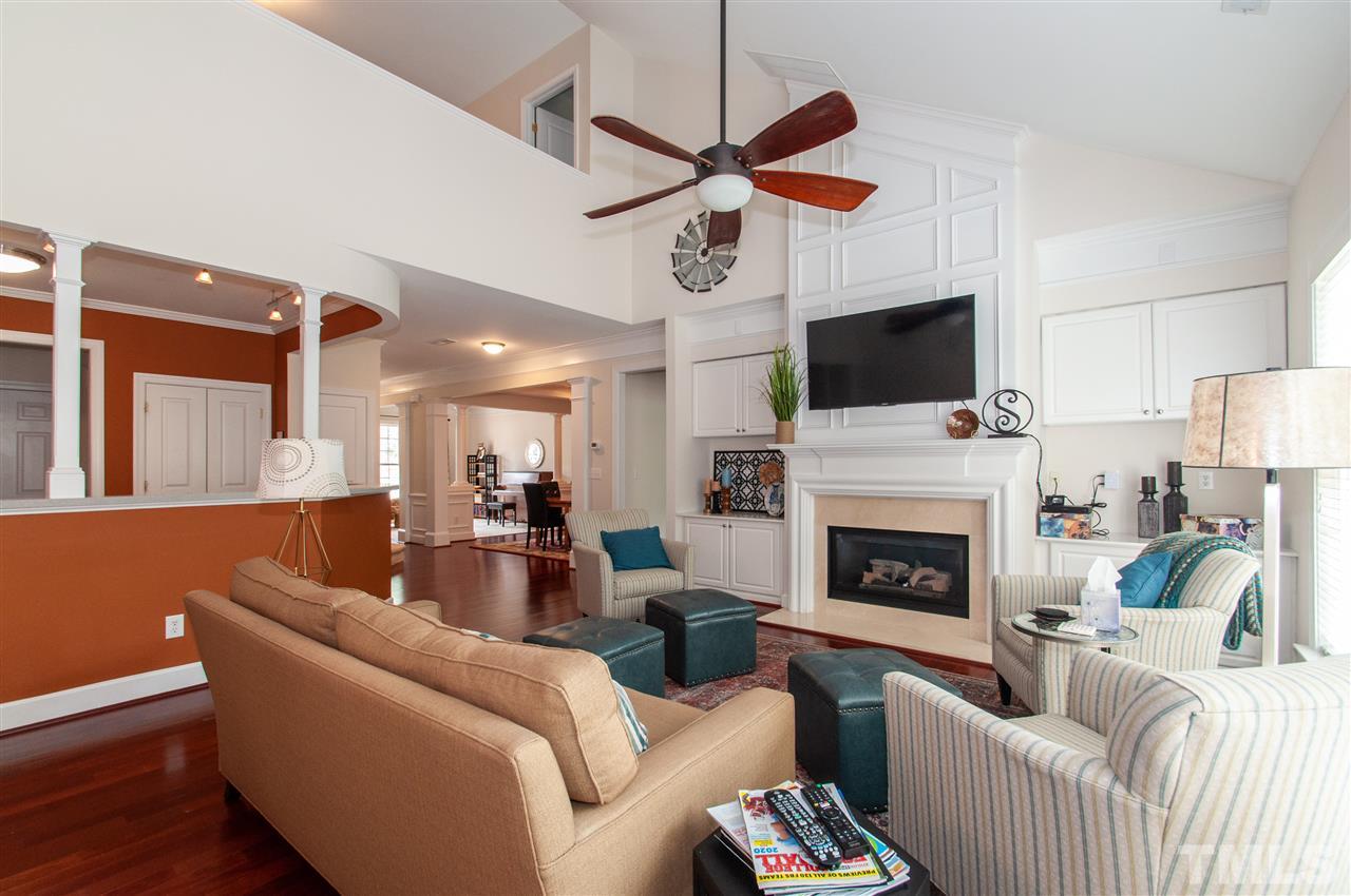 3615 Lion Ridge Court Raleigh, NC 27612 - Photo 3 of 30 a living room with furniture a flat screen tv and a fireplace