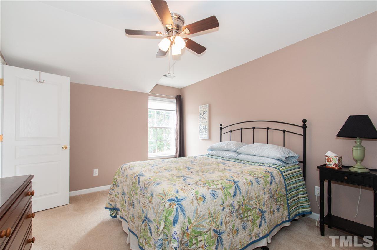 3615 Lion Ridge Court Raleigh, NC 27612 - Photo 22 of 30 a bedroom with a bed and a chandelier