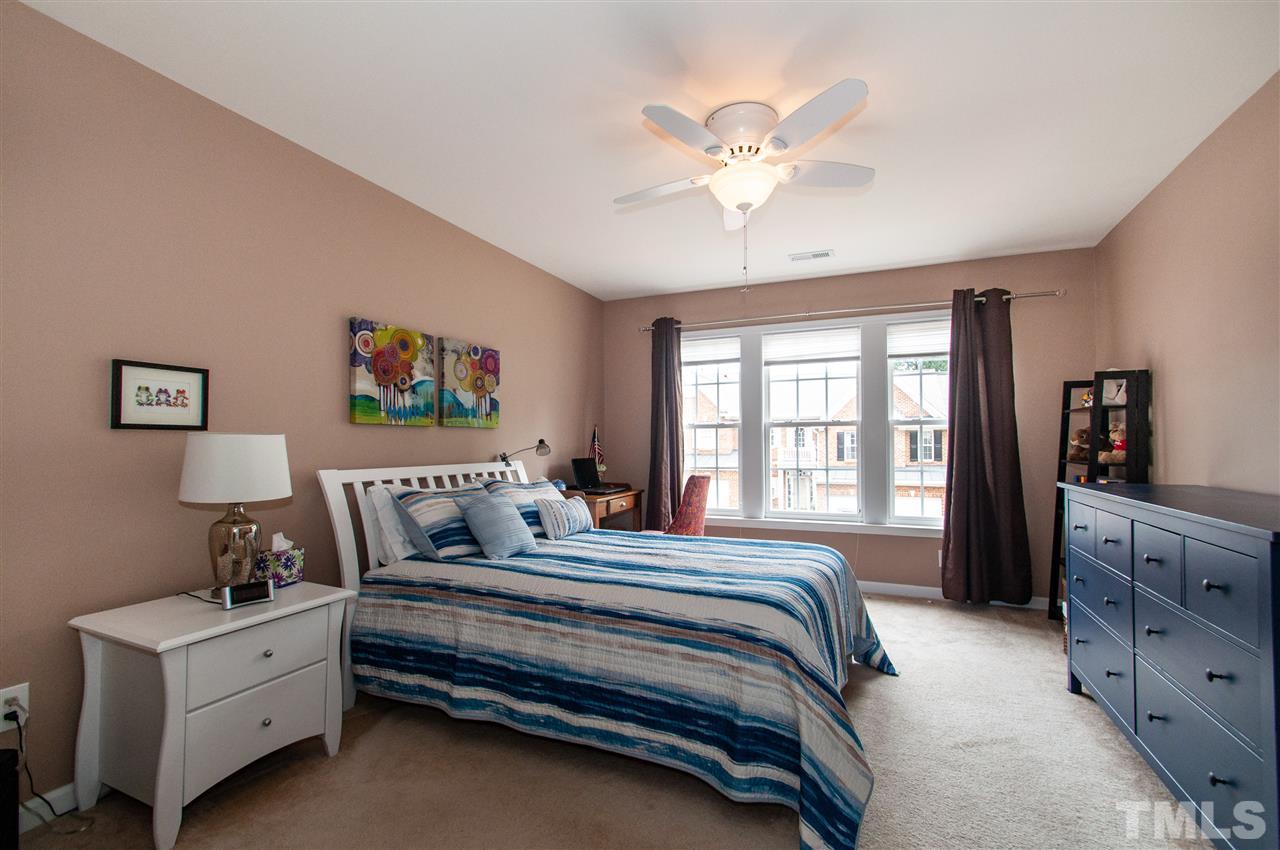 3615 Lion Ridge Court Raleigh, NC 27612 - Photo 25 of 30 a bedroom with a large bed and a chandelier
