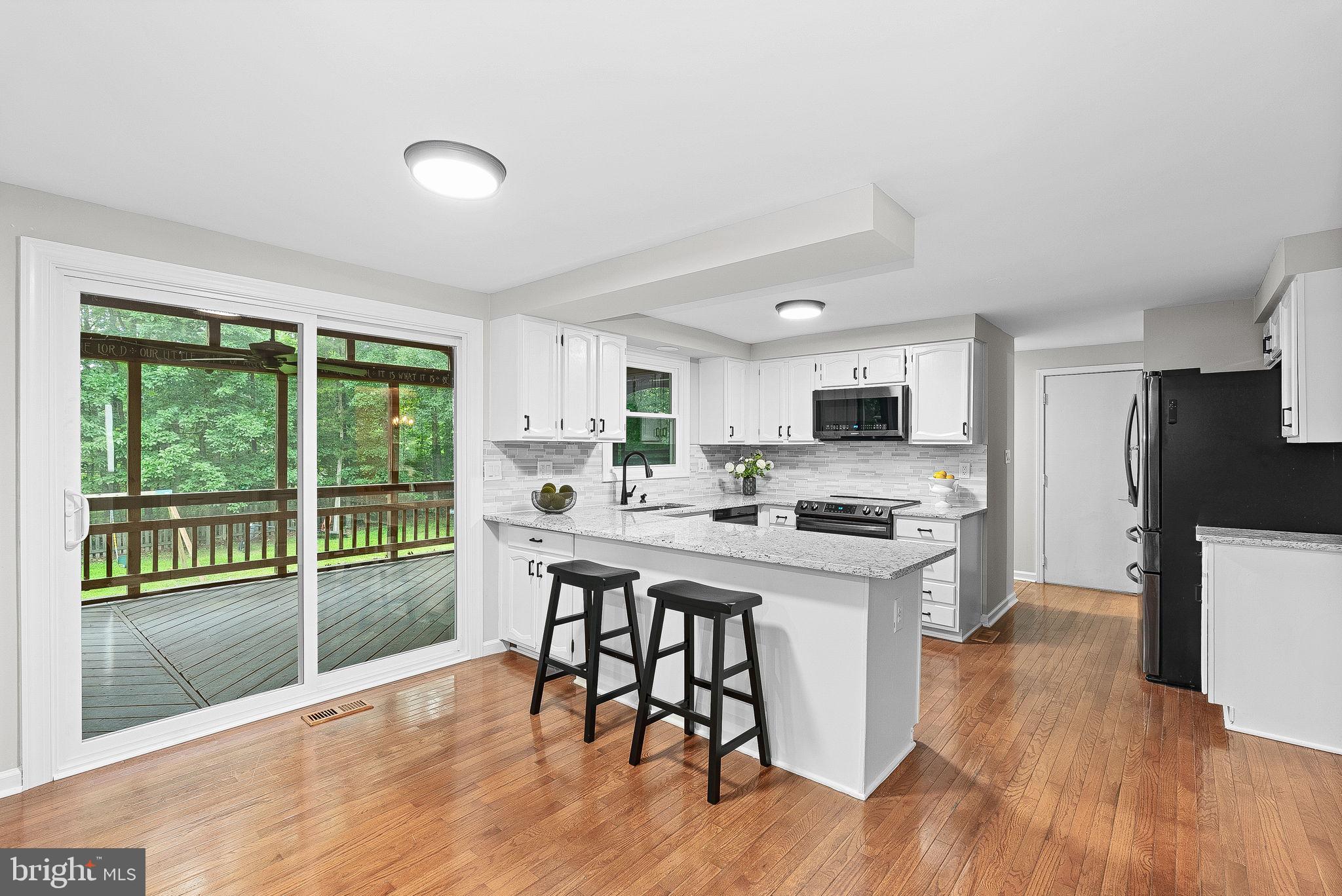 128 Applegate Drive Sterling, VA 20164 - Photo 17 of 58 a kitchen with stainless steel appliances granite countertop a stove top oven a sink dishwasher a dining table and chairs with wooden floor