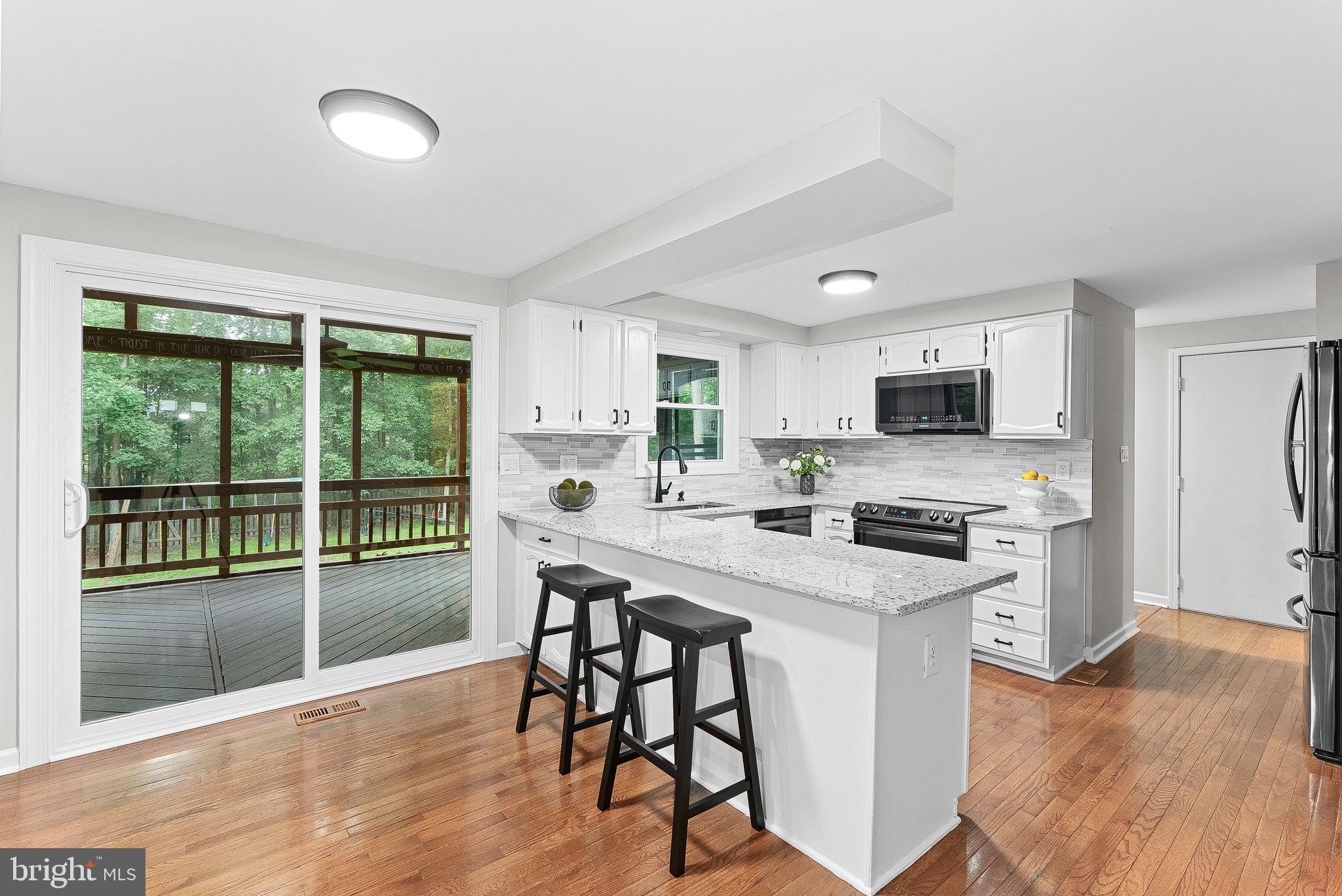 128 Applegate Drive Sterling, VA 20164 - Photo 19 of 58 a kitchen with stainless steel appliances a stove top oven a sink a refrigerator white cabinets and wooden floor