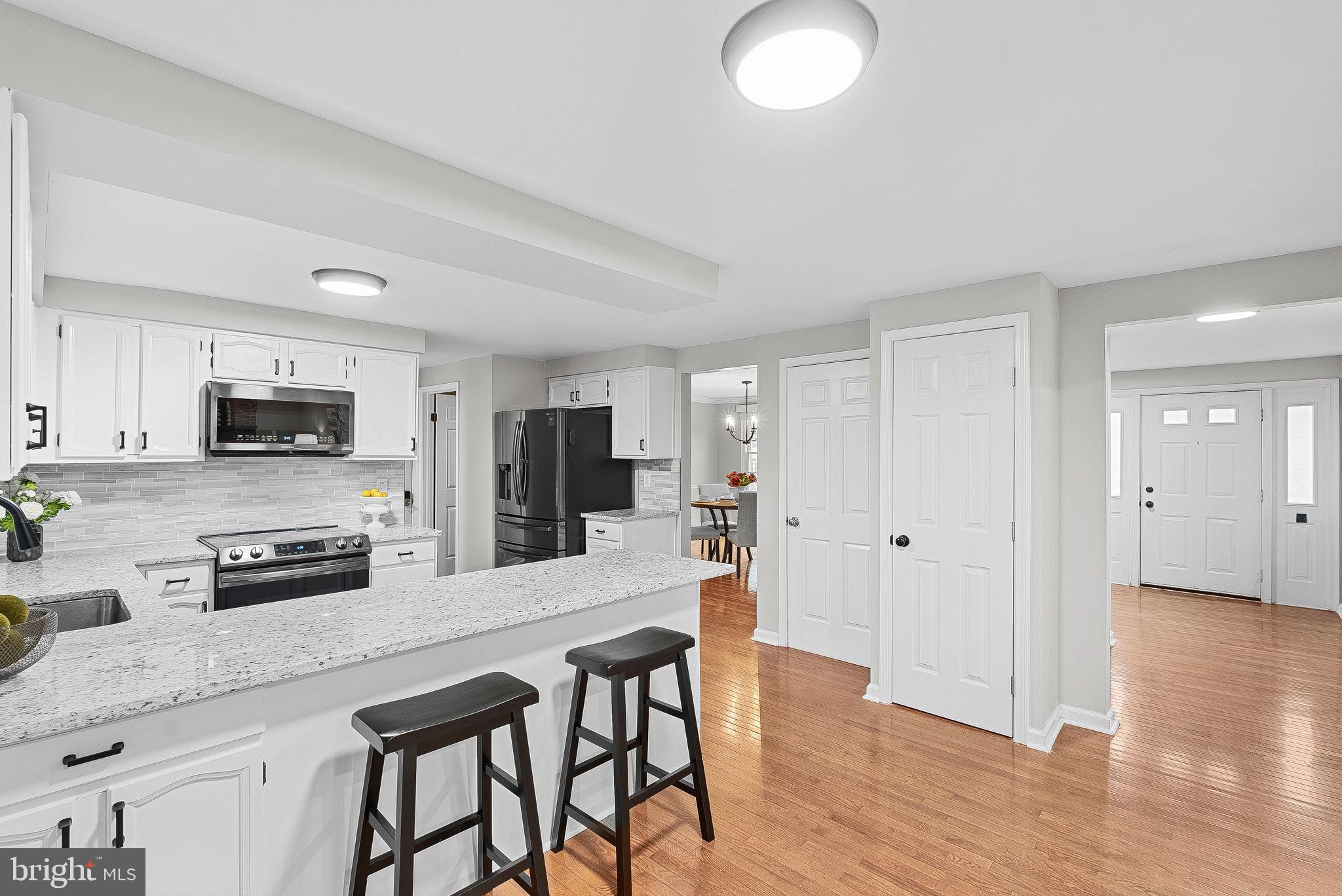 128 Applegate Drive Sterling, VA 20164 - Photo 23 of 58 a kitchen with stainless steel appliances granite countertop a stove top oven a sink dishwasher and a refrigerator with wooden floor