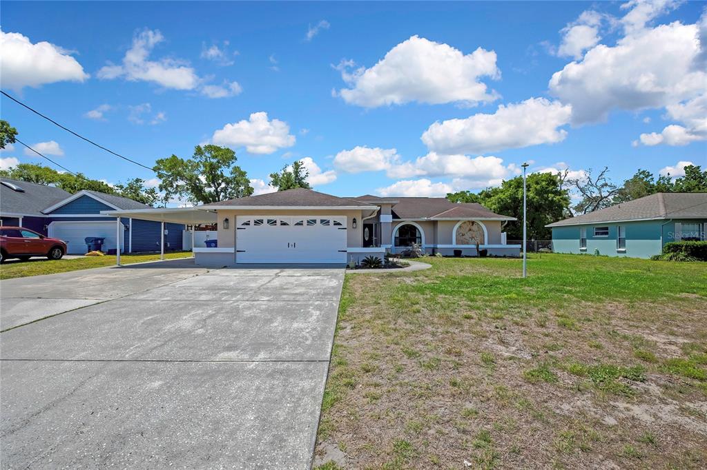 14154 Trollman Street Spring Hill, FL 34609 - Photo 1 of 25 a front view of house with yard